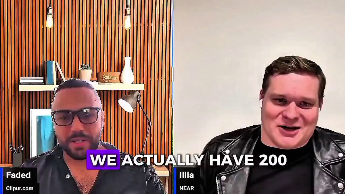 The image features two men wearing sunglasses, one sitting behind the other with their faces close together. The background includes a wooden wall and a shelf filled with various items such as books and vases. The caption for the image reads "We actually have 200 near". This phrase is likely an inside joke or reference to a specific event involving the number 200.