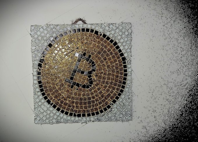 An ornate mosaic artwork depicting a musical note against a golden spiral background, mounted on a textured gray wall.