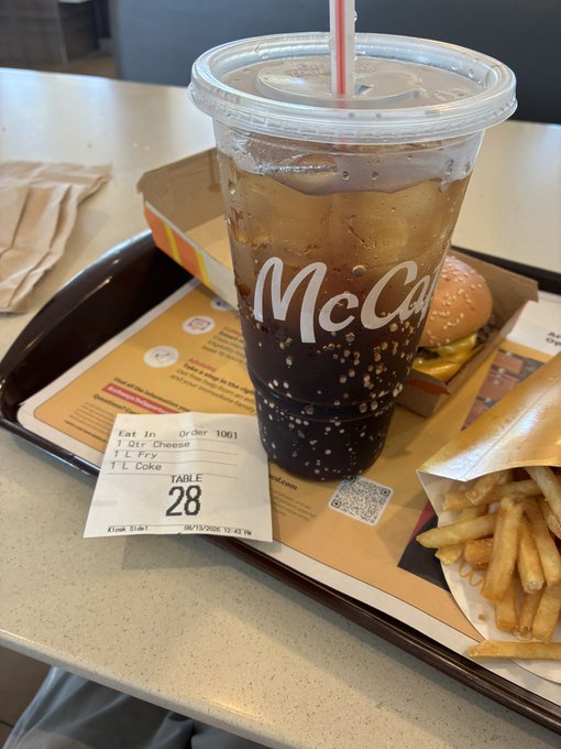 A McDonald's tray displays order #1061 (table 28) with a McCafé drink that appears to be a mix of dark soda (Dr Pepper) and clear liquid (water/cola), along with a Quarter Pounder cheeseburger and fries, humorously illustrating the "half water, half Dr Pepper" complaint in the caption.