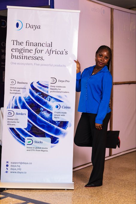A woman in a blue blouse stands next to a promotional banner for 'Daya - The financial engine for Africa's businesses', advertising features like Business, Borders, Coins, Stocks, and Daya Pro.
