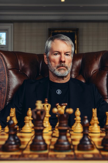urn of gold and black chess pieces, with a man in a black suit seated at the table, contemplating his next move.