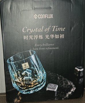 A black Conflux-branded gift box titled 'Crystal of Time / 时光淬炼 光华如初' with the tagline 'Every brilliance is born from refinement,' featuring an image of a crystal whiskey glass.