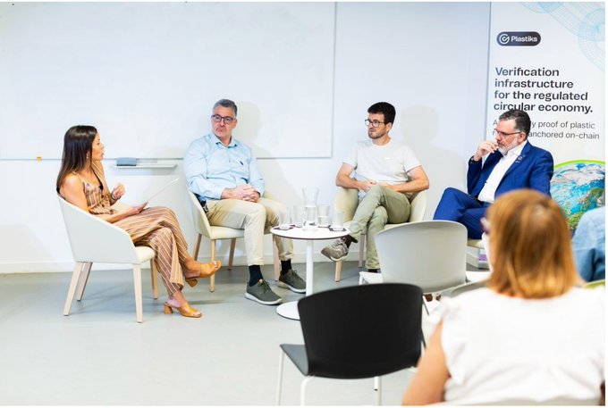 A panel discussion with four seated speakers on stage under a banner reading 'Plasticx: Verification infrastructure for the regulated circular economy.'