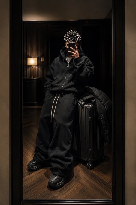 !"ZilyCc" is a social media account that features fashion and lifestyle content, including photos of people taking selfies with their luggage. The person in the image is posing for a photo while wearing a black outfit and holding a suitcase.
