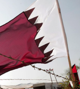 The image shows a flag of Qatar, which may be relevant to a discussion about global economics and potential propaganda surrounding it, as suggested by the accompanying post. The post implies that news related to countries like Qatar, potentially concerning oil prices or economic stability, might be used for political maneuvering by figures like Trump.