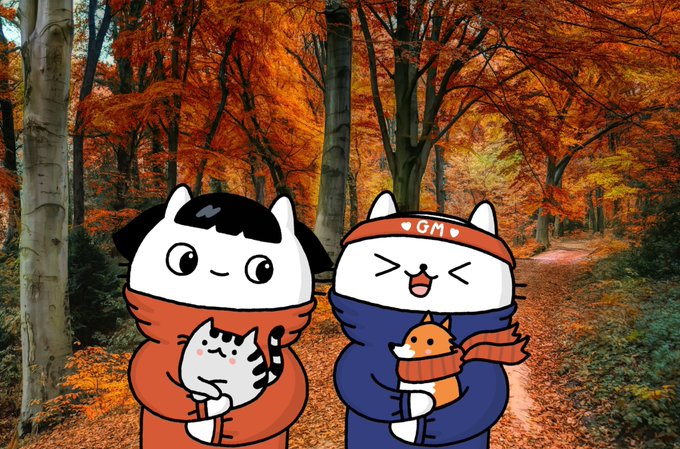 Illustration of two cartoon cats wearing scarves—one orange holding a cat, one blue wearing a 'GM' headband holding a fox—set in a vibrant autumn forest.