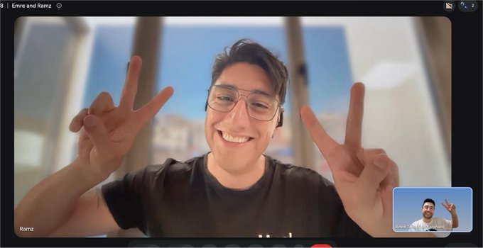 A video call screenshot titled 'Emre and Ramz' shows a smiling young man with glasses making peace signs with both hands, with a small picture-in-picture video of another person in the bottom right corner.