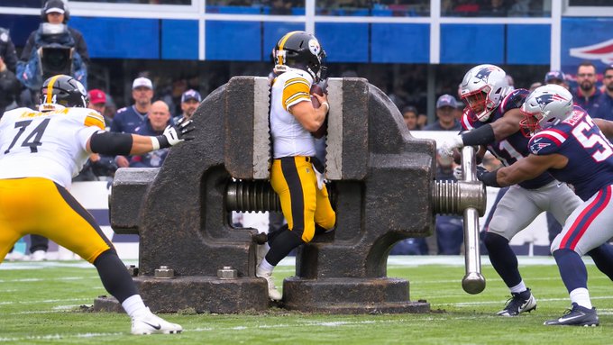 A surreal edited image showing NFL football players in Pittsburgh Steelers and New England Patriots uniforms positioned around a giant metal vise/clamp on the field, with player #74 (Steelers) and #57 (Patriots) visible.