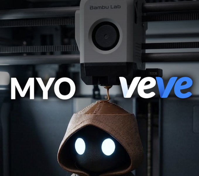 The image features a robot with a hooded head wearing a white hat that has "MYO" written on it. The robot appears to be made of wood or plastic and is positioned above a machine, possibly a 3D printer. The background of the image is dark, which contrasts with the bright colors of the robot's headwear and the text on the image.