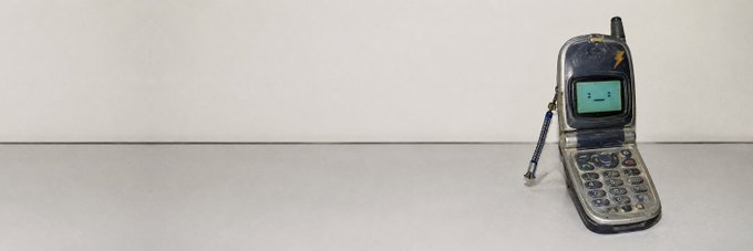 An open old-school flip phone with an antenna sits on a white surface, representing the “Dumb Phone Gang” and its anti-app, simplicity-focused $DPG Solana meme. No contract address is visible after “CA:” in the image.