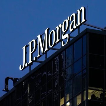 The image shows the exterior of a JPMorgan building, with the visible sign “J.P. Morgan.” It accompanies a report that JPMorgan Asset Management forecasts Bitcoin could deliver 10% annualized returns over the next 10–15 years and has included BTC in its long-term return forecasts for the first time.