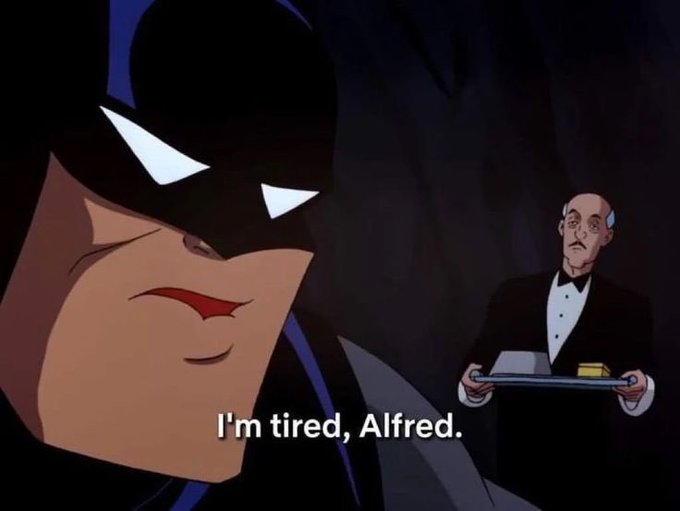 A screenshot from an animated Batman film showing Batman saying 'I'm tired, Alfred.' while Alfred stands behind him holding a tray.