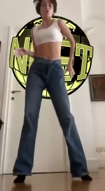 The image features a woman wearing blue jeans, standing in front of a door with her arms outstretched as if she's dancing or performing some kind of dance routine. The background includes a logo for "neet" and an image of a bull, which could be related to a dance-related event or competition. The post also mentions that the woman is logging off for the foreseeable future, possibly indicating that she has completed her performance or dance session and is now taking a break from dancing.