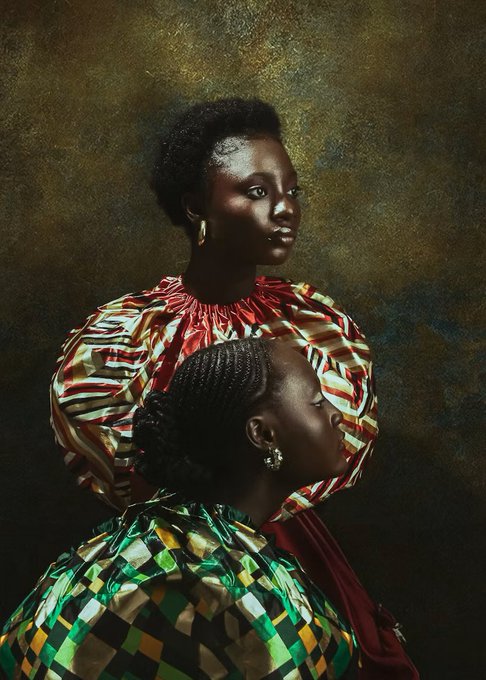 Two women in vibrant, patterned traditional African garments pose against a moody, textured backdrop in a portrait reminiscent of classical Renaissance paintings. Titled "Daughters," the regal composition conveys heritage, strength, and intimacy, fittingly priced at 0.200Ξ (Ethereum).