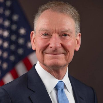 A headshot of SEC Chair Paul Atkins, a smiling older man with gray hair wearing a dark suit and blue tie, with an American flag visible in the background. The image directly corresponds to the post, which features Atkins' bullish statement on the impending passage of the Crypto Clarity Act.