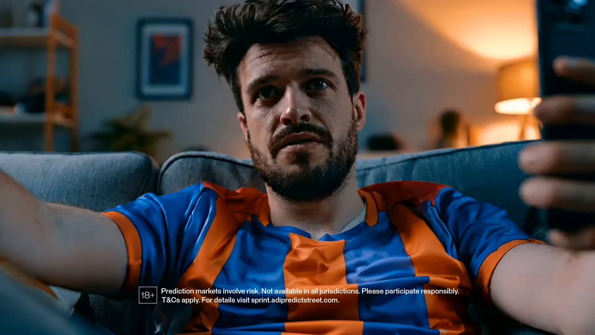 The image shows a man sitting on a couch with his arms crossed while holding a cell phone. The text in the image reads "Free card claimed, daily packs opened, now it's time to chase the leaderboard relentlessly." This suggests that the man is likely discussing or sharing information about a recent purchase of a free card for daily packs and how he plans to use them on his favorite streaming platform like YouTube.