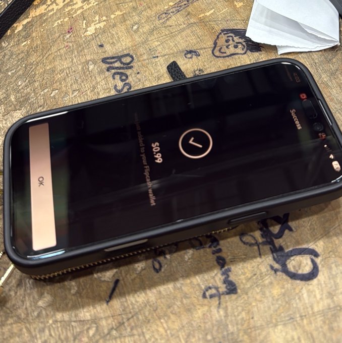 A smartphone lies on a scratched wooden surface, displaying a lock screen with the time '7', date 'Thursday, January 2', and text 'Has been added to your FIDO2 key resident' and 'Success'.
