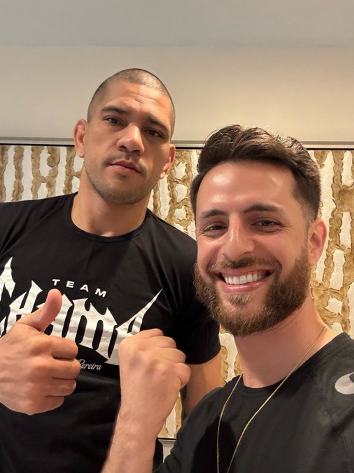 Two friends pose for a selfie, with the man on the left wearing a black "TEAM Amanda" t-shirt and giving a thumbs-up, while the bearded man on the right smiles broadly—embodying the post's theme of finding happiness and success through "internet money" alongside like-minded friends.