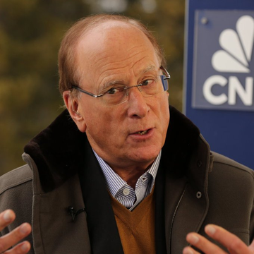 An older man with glasses and a dark jacket gestures while speaking in front of a CNN logo backdrop.
