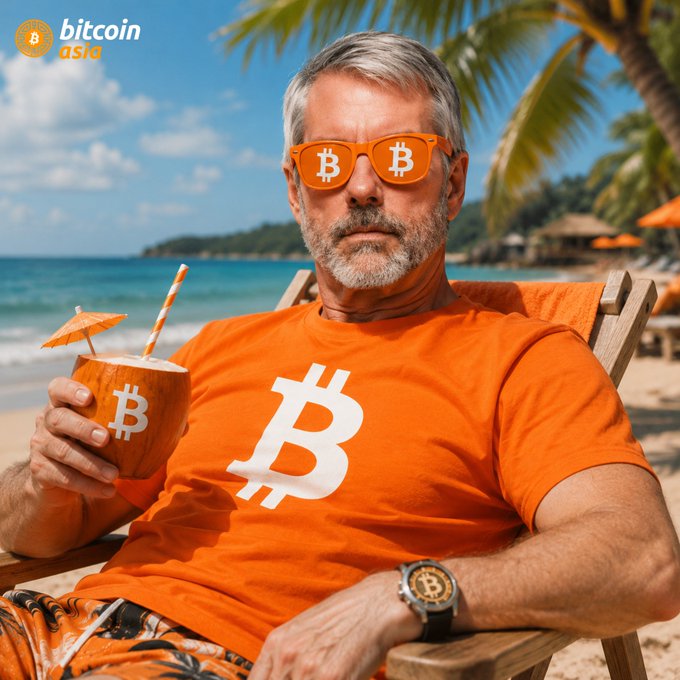 The image features a man sitting on a beach chair, wearing an orange t-shirt with a Bitcoin symbol on it. He has sunglasses on his head that have Bitcoins printed on them. The man also holds a drink in a straw, which is likely a coconut-flavored beverage. The scene suggests a relaxed and enjoyable atmosphere, possibly related to the Bitcoin community or cryptocurrency enthusiasts gathering at the beach for a fun day out.