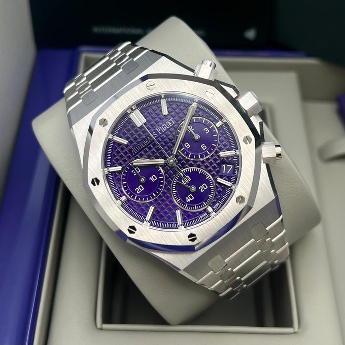 An Audemars Piguet Royal Oak chronograph watch with a purple dial and stainless steel bracelet displayed in its box.