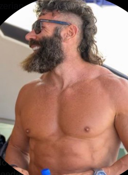 A shirtless, muscular man with a thick beard and long curly hair (a mullet-style cut) wearing sunglasses smiles while looking off to the side. The image relates to the caption as it depicts Dan Bilzerian, the subject of the joke about having negative odds on Polymarket, fitting the satirical context of a presidential candidate with such low support.