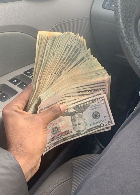 A hand fans out a thick stack of U.S. $20 bills inside a car, while the post pitches an early money-making investment opportunity, using the visual of cash as a hook to attract potential investors.