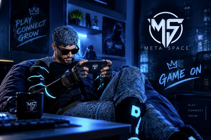 A promotional graphic for 'META SPACE' featuring a gamer in futuristic gear playing on a handheld device, with text 'PLAY CONNECT GROW' and 'GAME ON' displayed.