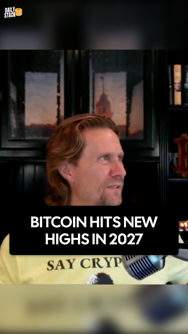 A man with long hair speaks into a microphone during an interview, with the text "BITCOIN HITS NEW HIGHS IN 2027" overlaid at the bottom. The image accompanies a quote from Cory Swan, CEO of Swan, predicting Bitcoin will reach new all-time highs in 2027, shorter than previous four-year cycles.