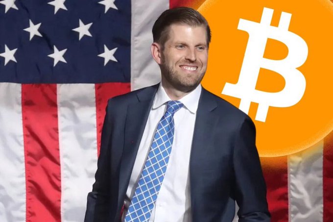 Eric Trump is pictured smiling in a suit against an American flag, with a large orange Bitcoin logo on the right side.