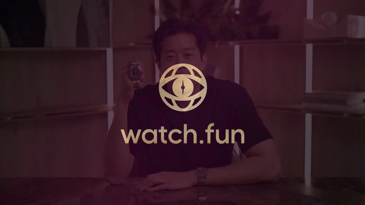 The image features an advertisement for Watch.Fun, which has a man sitting at a desk with a remote control in his hand. He appears to be watching TV or playing video games while wearing a black shirt. The background of the image shows a wooden shelf filled with books and other items.