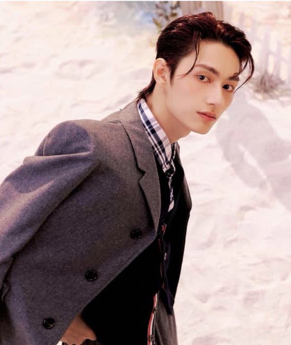 The post humorously captures the relatable feeling of jealousy, as a stylish young man with slicked-back hair and a confident pose wears a grey blazer over a checkered shirt, perfectly embodying the smug "main character" energy that would leave followers fuming with envy.