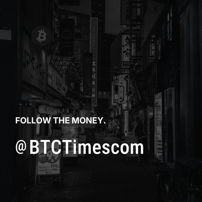 The image shows a city street at night, featuring tall buildings and various signs. The main focus of the image is a black and white photograph that reads "Follow the money. #btcTimescom" with a hashtag symbol (#). This text is located in the bottom right corner of the photo.