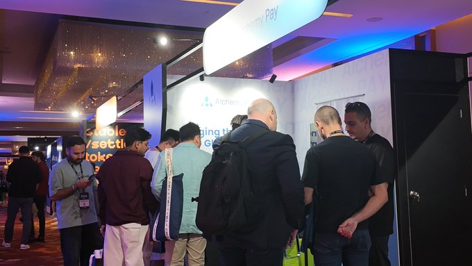 Attendees gather at Booth PB4-7 for AlchemyPay at TOKEN2049 Singapore, engaging with staff beneath a "Crypto Pay" banner and Alchemy Pay-branded signage on Day 1 of the conference.