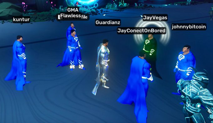 A screenshot from a virtual gathering with several user names visible above avatars, including 'kuntur', 'GMA', 'Flawlessfile', 'Guardianz', 'JayVegas', 'JayConectOnBored', and 'johnnybitcoin', with most figures wearing matching blue capes.