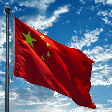 The image features a red flag with yellow stars, flying high against a blue sky filled with white clouds. The flag appears to be waving in the wind, creating a sense of movement and energy. In the background, there are some text elements that read "CRAPNEWS- #China is building #ai based futures markets & turning ai into a tradable asset class xrp & Altcoins". This suggests that the image might be related to an article or news piece discussing China's involvement in cryptocurrency trading and its impact on traditional financial markets.