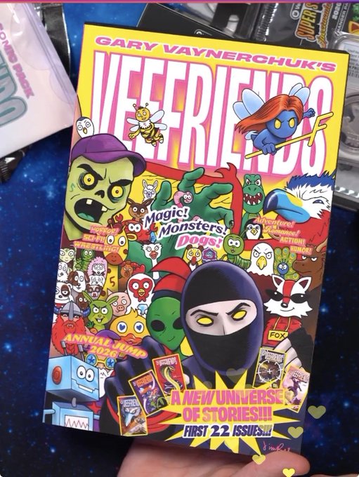 A comic book titled 'GARY VAYNERCHUK'S VEEFRIENDS' with text 'A NEW UNIVERSE OF STORIES!!! FIRST 22 ISSUES!!!' held up to the camera.