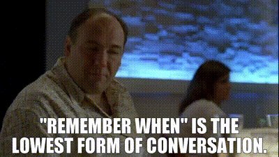 A man with a bald head and mustache, wearing a white shirt, sits at a table with a woman in the background, accompanied by text about conversation.