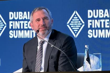 Ripple CEO Brad Garlinghouse speaks at the Dubai Fintech Summit, appearing in front of a branded backdrop as he discusses how XRP and stablecoins can complement each other in addressing different cross-border payment needs.