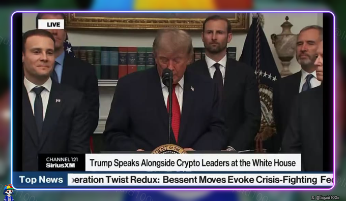 A SiriusXM news broadcast screenshot showing President Trump speaking at a White House podium, with the headline "Trump Speaks Alongside Crypto Leaders at the White House" and a ticker reading "Bessent Moves Evoke Crisis-Fighting Ferv".
