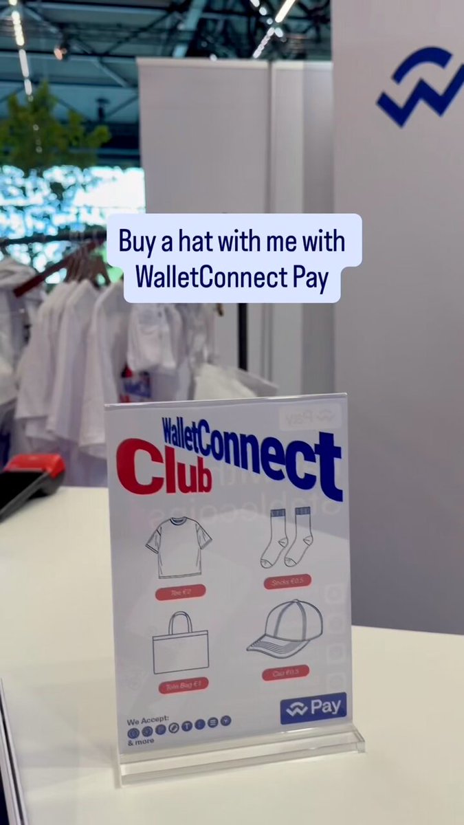 The image shows a sign for a wallet connection payment system that allows users to buy merchandise online using cryptocurrency. The sign has a picture of clothing items, including a hat, displayed on it. It also includes text promoting the use of cryptocurrency as an easy way to purchase items and pay with crypto. The post encourages people to use WalletConnect Pay to make purchases without any hassle or conversion issues.