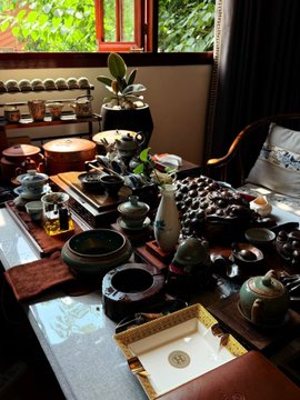 An elegant traditional Chinese tea ceremony setup fills a sunlit table with an array of small teacups, teapots, and tea accessories arranged on dark stone and wooden trays. Complementing the post's message about mental recharge, the serene scene invites one to slow down, sip tea, and let the mind "close for the day" amid the calming ritual of tea.
