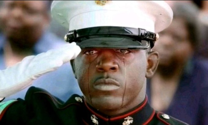 A Marine in dress uniform stands at attention, saluting with tears streaming down his face beneath his white cap. The somber, dutiful expression captures the stoic discipline required to endure painful obligations — fitting the caption about forcing a smile at a girlfriend's family gathering while missing out on something more important.