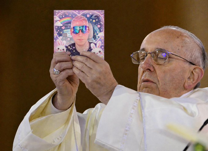 Pope Francis holding up a holographic card featuring a colorful image of a person wearing sunglasses, with bunnies and a rainbow in the background.