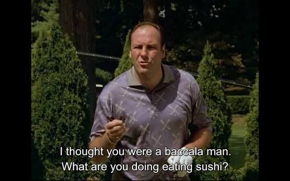 Screenshot from a video showing a man in a patterned polo shirt outdoors with subtitles reading 'I thought you were a baccala man. What are you doing eating sushi?'