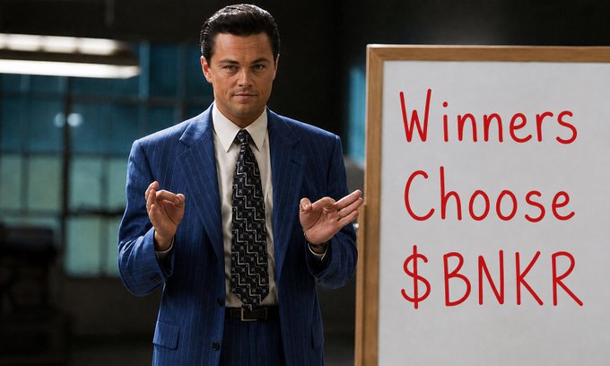 A man in a blue suit mimics the 'Wolf of Wall Street' pose next to a whiteboard reading 'Winners Choose $BNKR'.