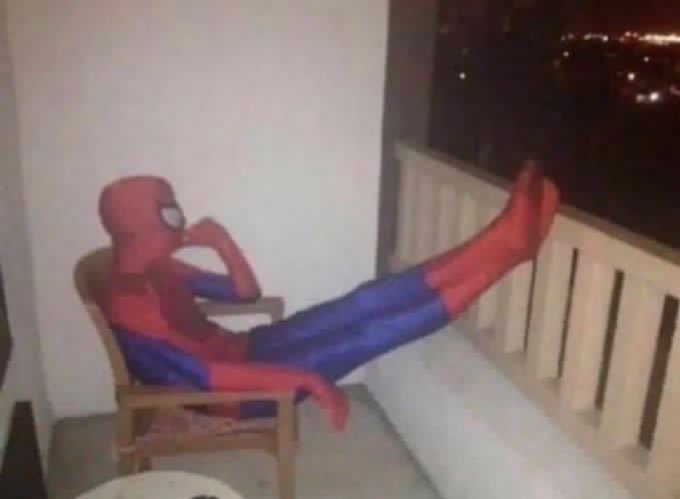 The image features a Spiderman character sitting in an office chair, wearing his signature red suit with blue accents. The spiderman appears to be posing or relaxing while seated at a desk. The background of the image shows a cityscape, suggesting that the office is located within an urban setting. The caption provided seems unrelated to the scene and does not provide any relevant information about the Spiderman character or his actions in the image.