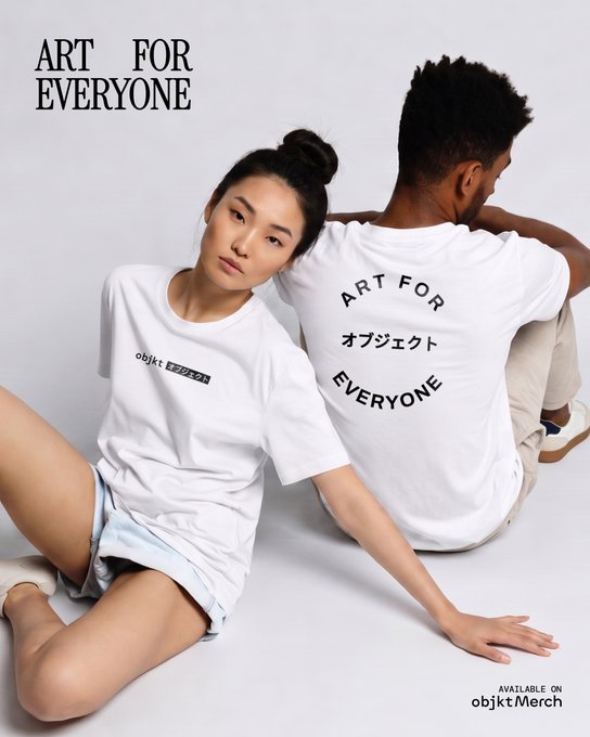 Two models sitting back-to-back wearing white t-shirts with 'ART FOR EVERYONE' printed on them, advertising obijkt merch.