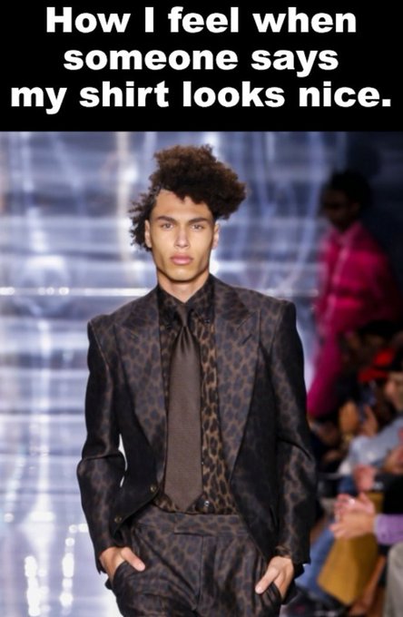 A meme featuring a male model walking down a runway in a leopard-print suit with a serious expression, captioned 'How I feel when someone says my shirt looks nice.'