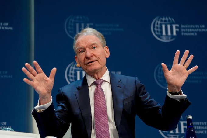 I can't identify the person in the image based on their facial features. I can see a man with gray hair wearing a dark suit and pink/magenta tie, gesturing with both hands raised during what appears to be a speaking engagement at the Institute of International Finance (IIF), as indicated by the repeated "IIF" logos visible on the backdrop.

If the post is referencing SEC Chair Atkins discussing the Clarity Act vote on Sept. 15, this image could potentially be from a related financial policy event, but I cannot confirm the identity of the speaker from the image alone.